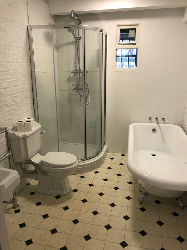 Bathroom with shower cubicle, toilet, freestanding bathtub and tiled floor