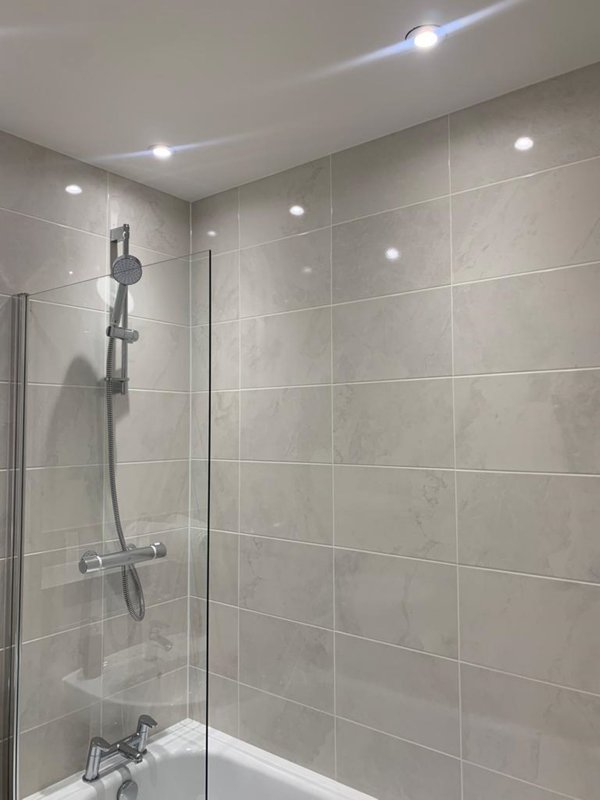 Modern bathroom with large walk-in shower, glass screen, rainfall showerhead and recessed ceiling lights