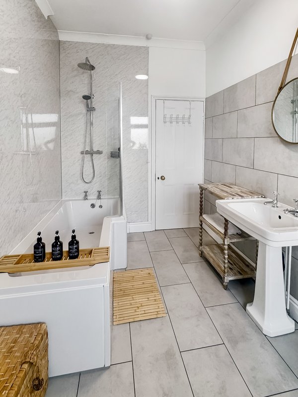 Modern bathroom with walk-in shower, freestanding bathtub, double sink and wooden accents