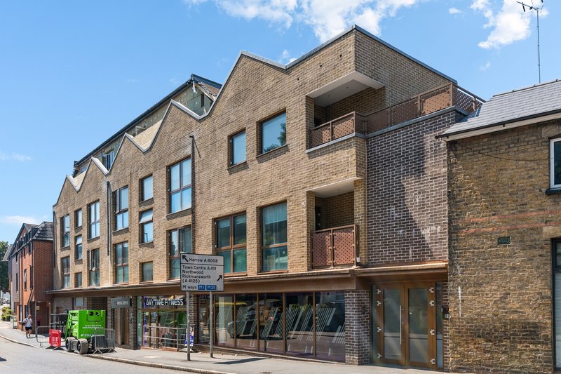 Multi-story brick building with ground-floor shops and residential units above