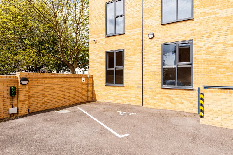 Modern brick building exterior with parking space, entrance door and windows
