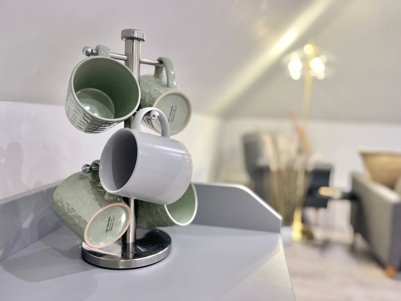 Kitchen counter with mug tree organizer and blurred background furnishings