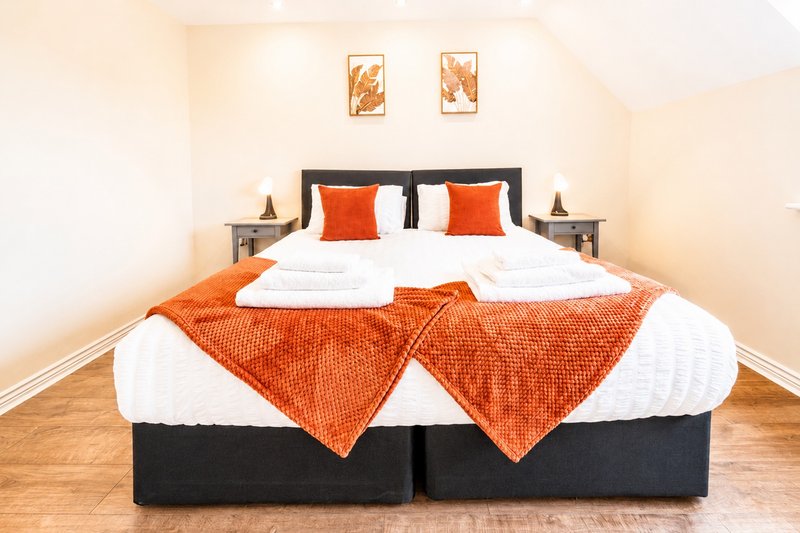Spacious master bedroom featuring flexible zip-link beds that can be configured as a luxurious king-size bed or two large single beds. Complete with fresh linens, bedside tables & soft lighting.