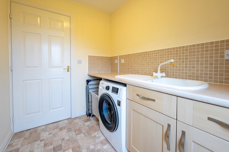 Convenient utility room equipped with a washing machine, sink & storage space. Perfect for longer stays.
