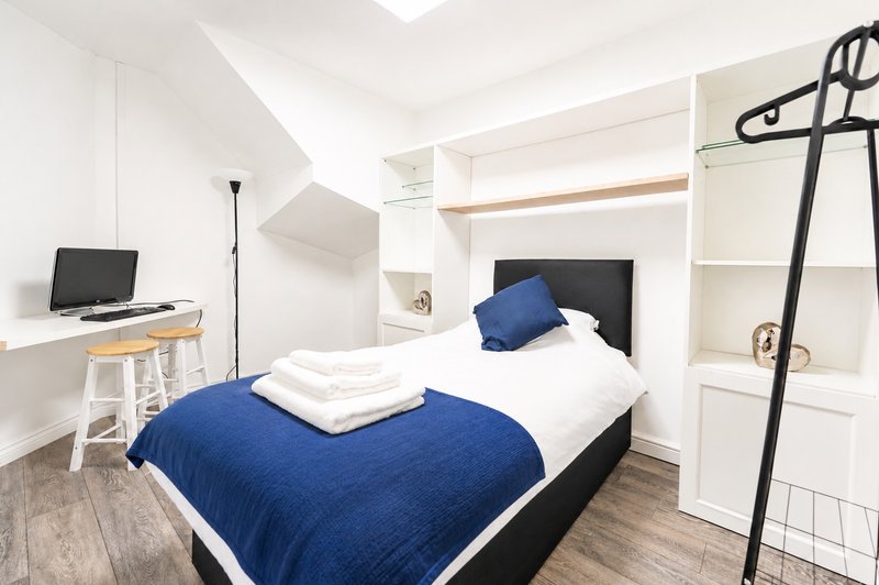 Comfortable ground-floor bedroom with a cosy large single bed, dedicated workspace, built-in storage, and fresh linens. Ideal for professionals, contractors, or longer stays,.