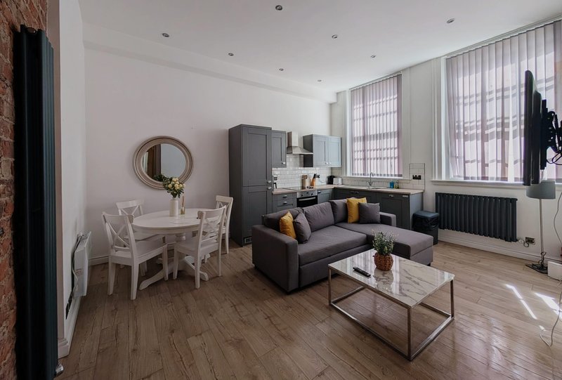 Modern open-plan living space with dining area, sofa, coffee table and kitchen