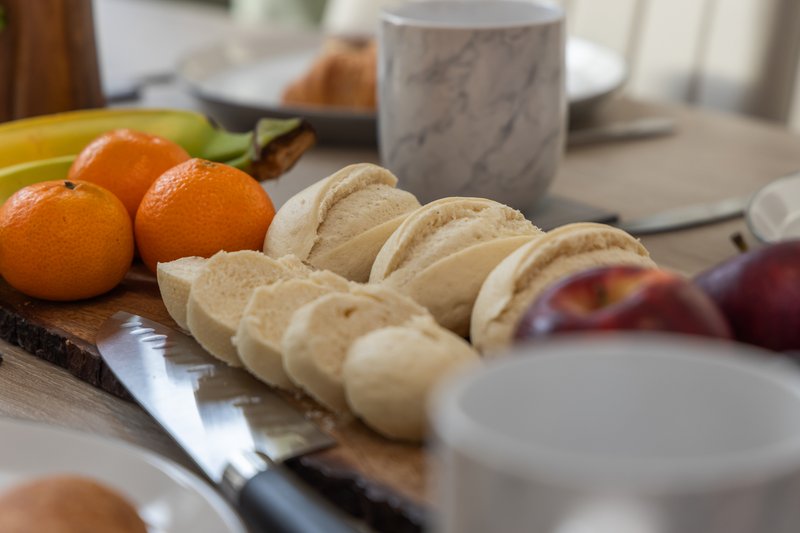 Kitchen counter with fresh oranges, tacos, plates and cup in soft daylight