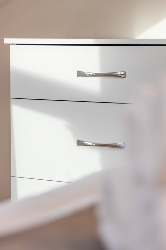 White kitchen cabinet with two drawers and chrome handles in natural light