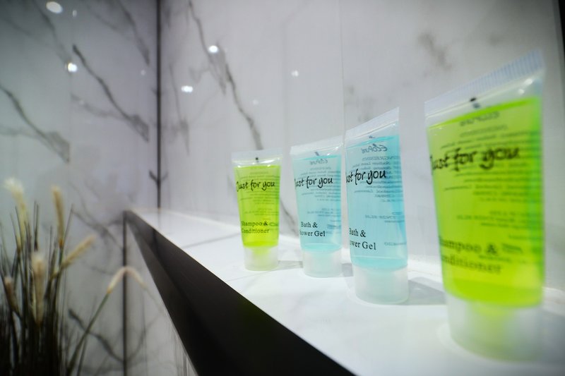 Modern bathroom shelf with marble wall, toiletries bottles, and decorative plant