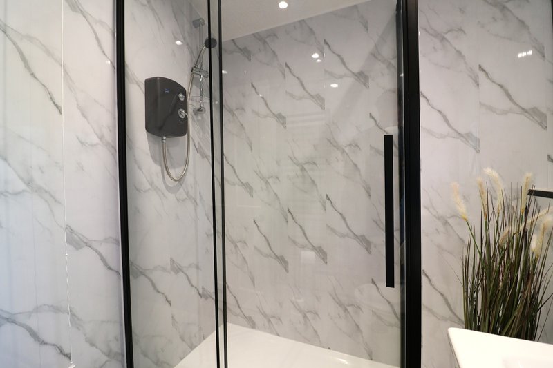 Modern bathroom with marble-tiled shower enclosure, black frame and fixtures