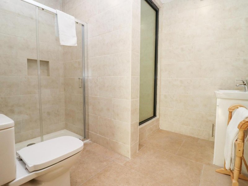 Bathroom with shower enclosure, toilet, sink, and towel rail