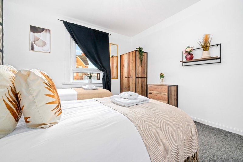 Modern bedroom with double bed, wooden furniture, decorative pillows and wall shelving
