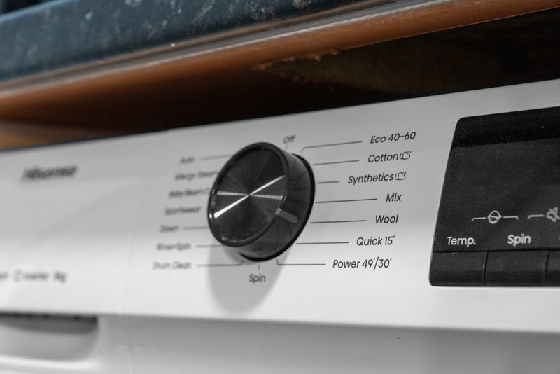 Close-up of washing machine control panel with dial and temperature settings