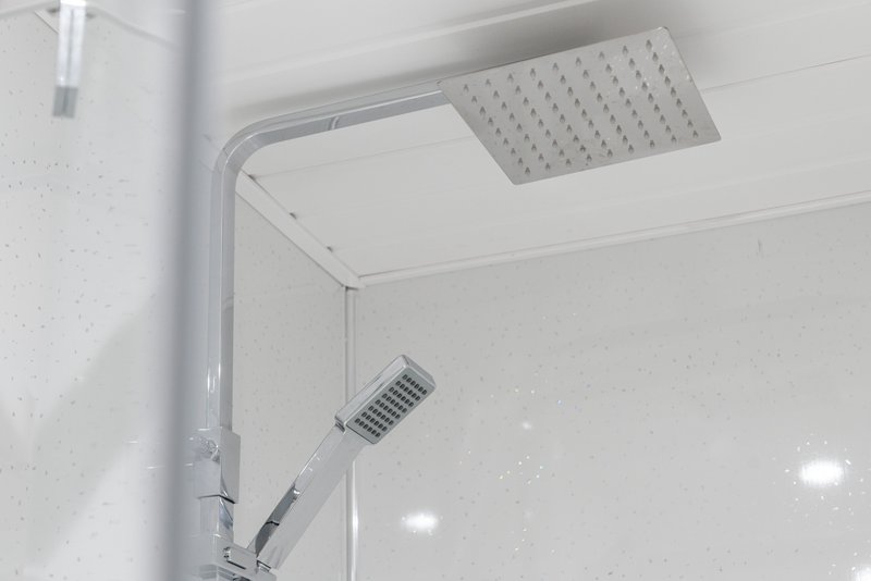 Modern bathroom shower with rainfall showerhead, handheld spray, and recessed lighting
