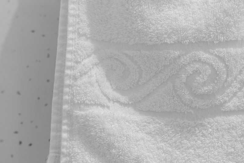 Close-up of white textured towel with decorative pattern and border detail
