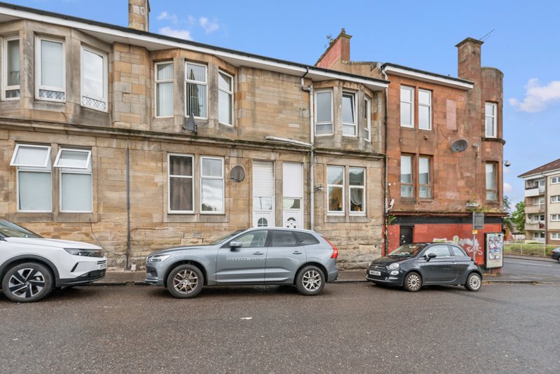 Traditional Scottish tenement building with parked cars on street frontage