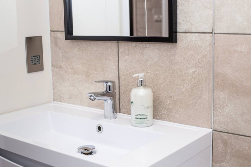 Modern bathroom sink with mirror, chrome faucet and soap dispenser