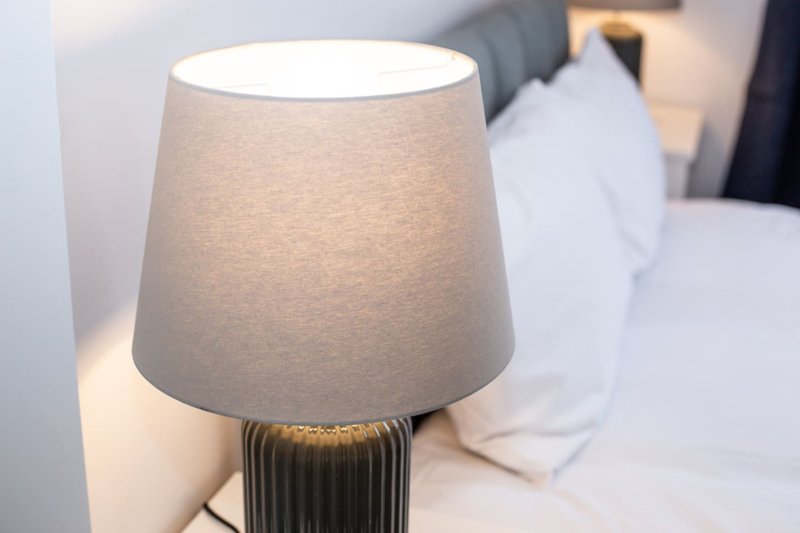 Bedroom bedside table lamp with cream fabric shade and ribbed base