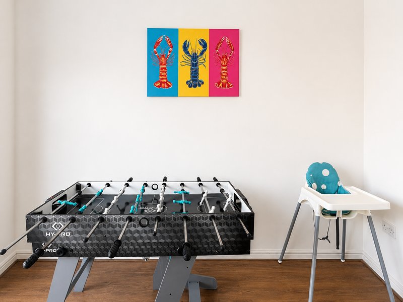 Recreation room with foosball table, high chair, and colorful wall art