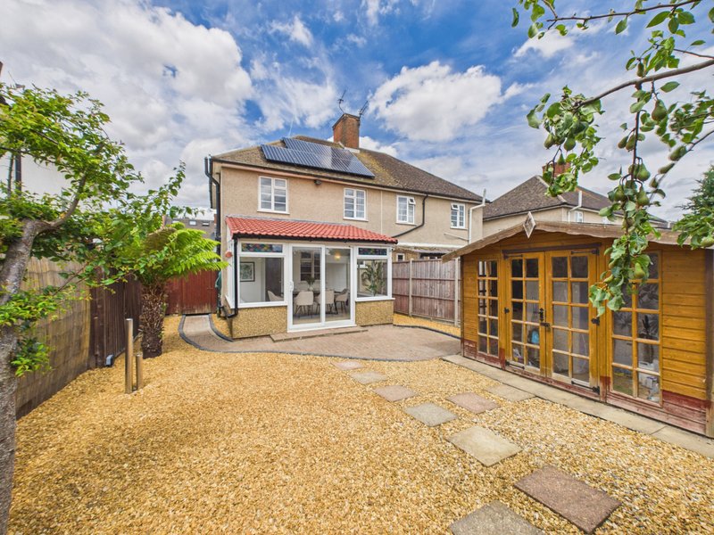 Semi-detached house with extended rear, gravel garden, wooden outbuilding and patio area