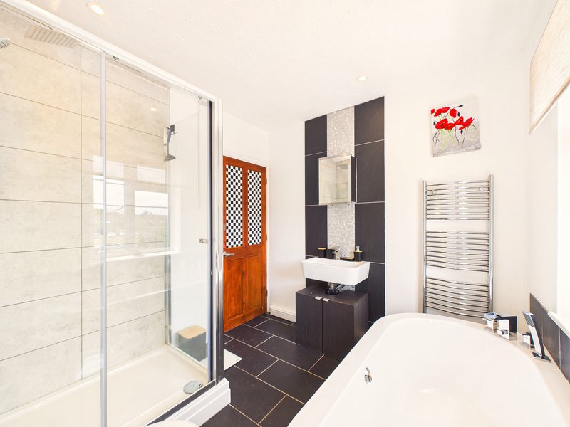 Modern bathroom with walk-in shower, freestanding bathtub, double sink vanity and heated towel rail