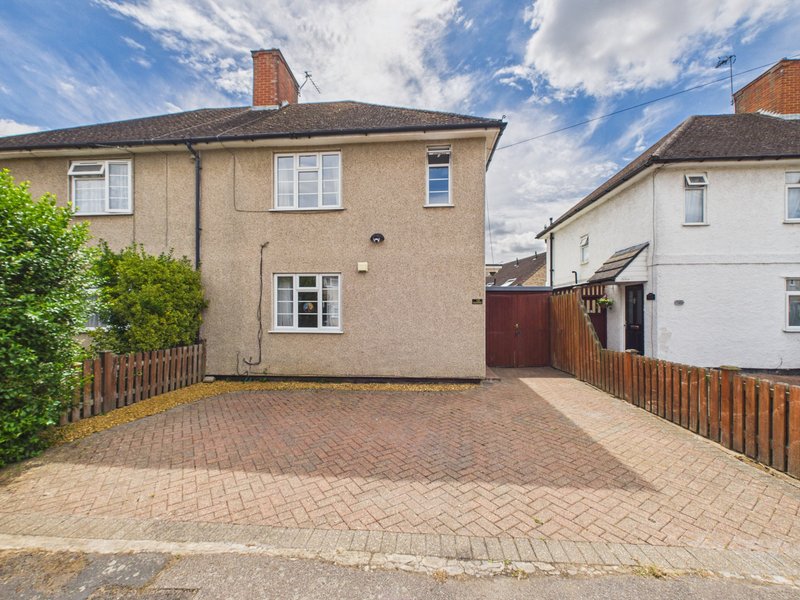 Semi-detached house with driveway, brick paving, wooden fencing and green hedge