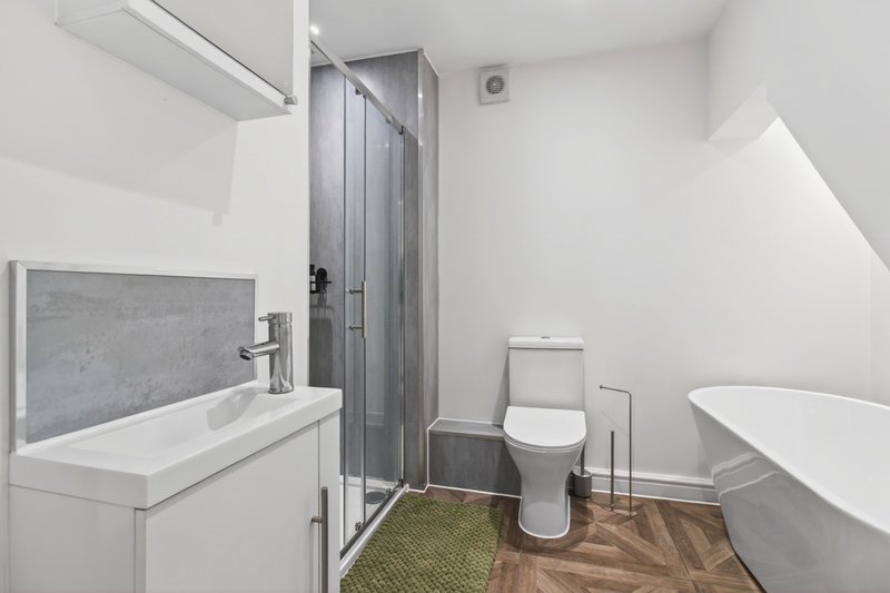 Modern family bathroom with separate shower enclosure, freestanding bath, WC and wash basin – ideal for contractor teams and comfortable longer stays.