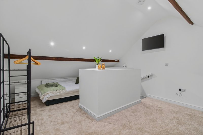 Spacious top-floor bedroom with flexible zip-link beds, configured as three separate singles for contractor teams. Includes Smart TV, clothes storage and plenty of space.
