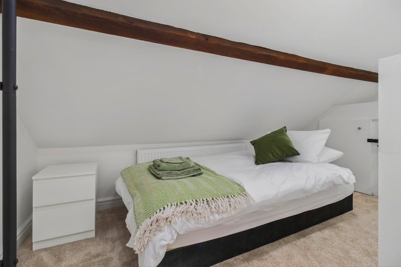 Bedroom 1 shown in an alternative zip-link configuration. The flexible beds can be arranged as three separate singles for contractor teams or joined together when required.