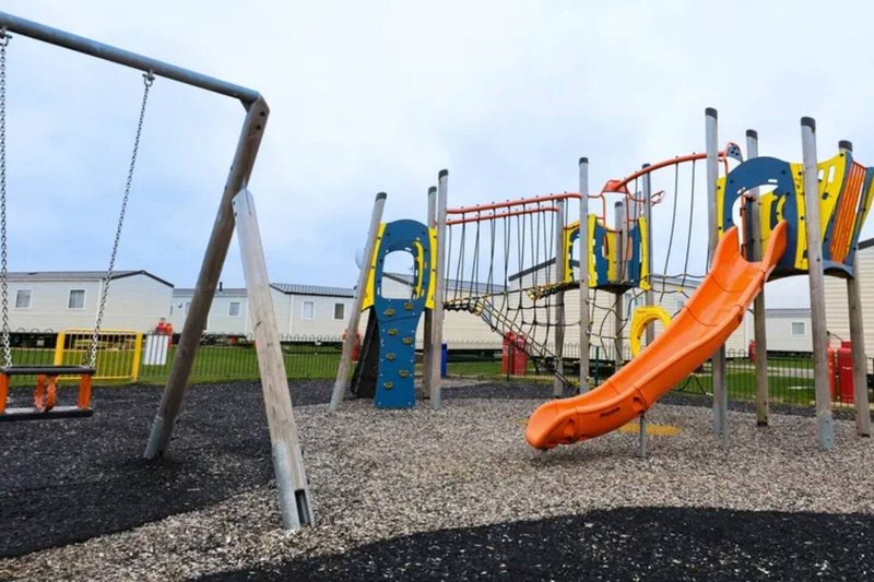 Outdoor children's playground with swings, slides and climbing structures