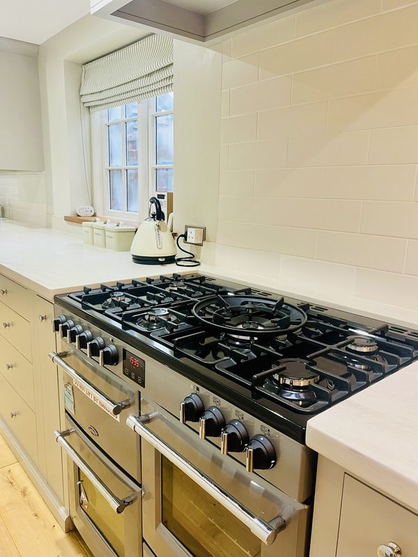 Modern kitchen with cream cabinets, stainless steel range cooker, and window above sink