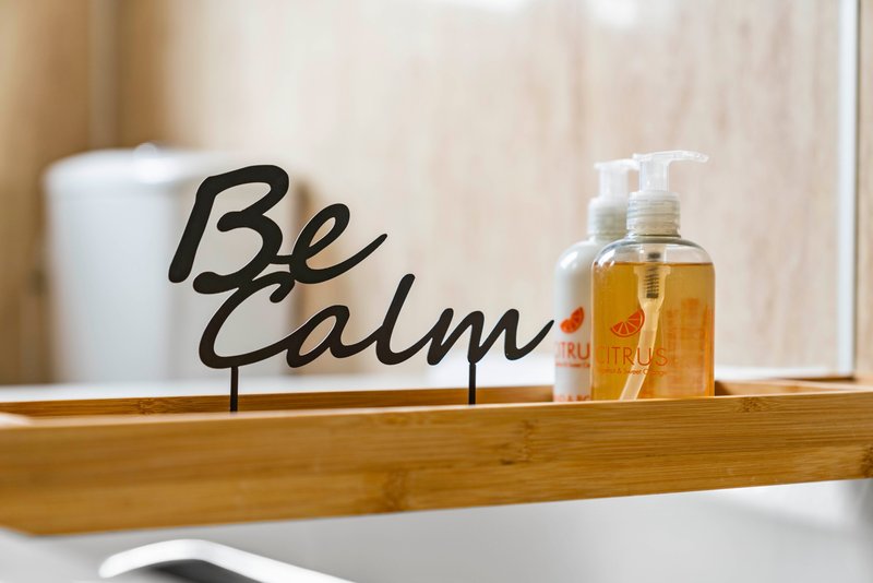 Bathroom shelf with soap dispenser, candle and decorative sign