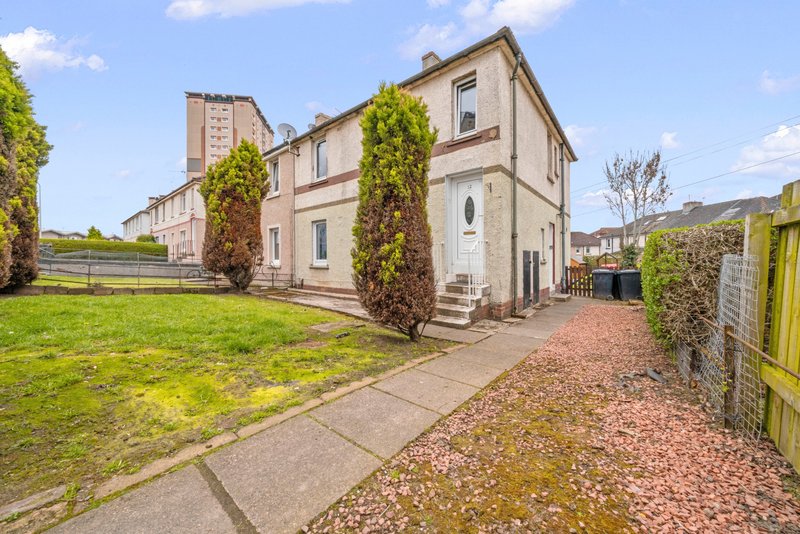 Semi-detached house with ivy-covered walls, front garden and driveway