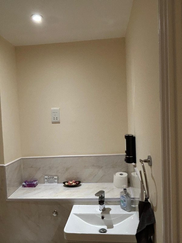 Bathroom with white sink, marble countertop, mirror and recessed lighting