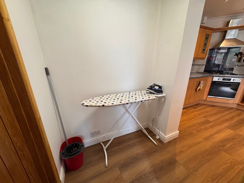 Kitchen utility area with ironing board and iron