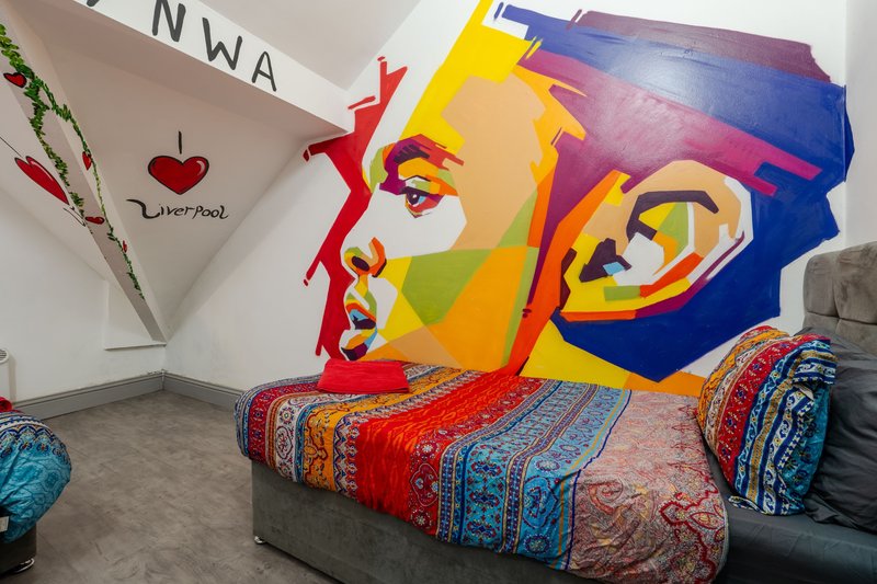 Modern bedroom interior with colorful pop-art wall mural and patterned bedding