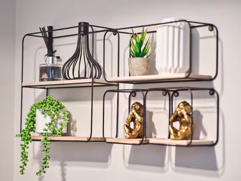 Wall-mounted metal shelving unit with plants, decorative items and home accessories