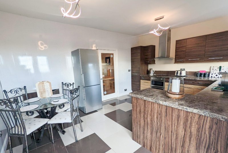 Open-plan kitchen and dining area with stainless steel appliances and granite countertop