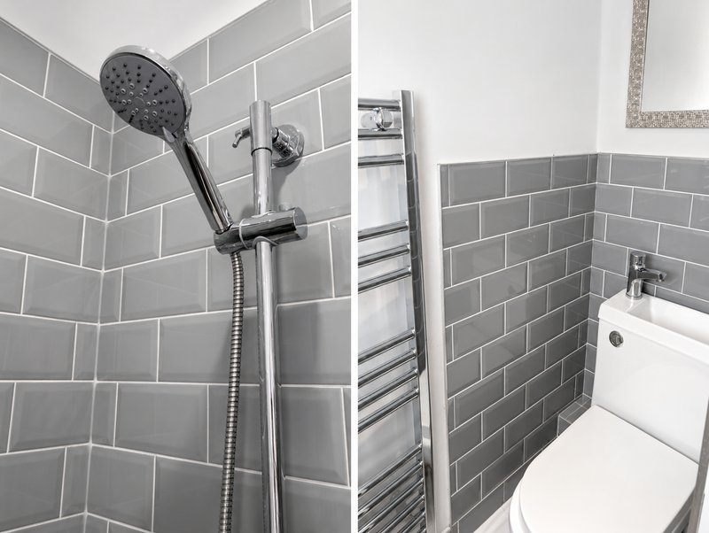 Modern bathroom with gray subway tiles, rainfall showerhead, heated towel rack and white toilet