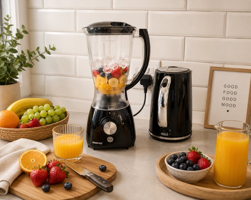 Kitchen counter with blender, fresh fruit, orange juice glasses, and potted plant