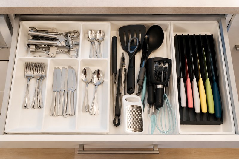 Kitchen drawer organizer containing cutlery, utensils, cooking tools and kitchen gadgets