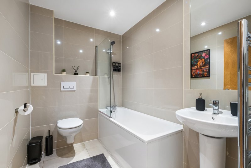 Modern bathroom with bathtub, toilet, pedestal sink and walk-in shower