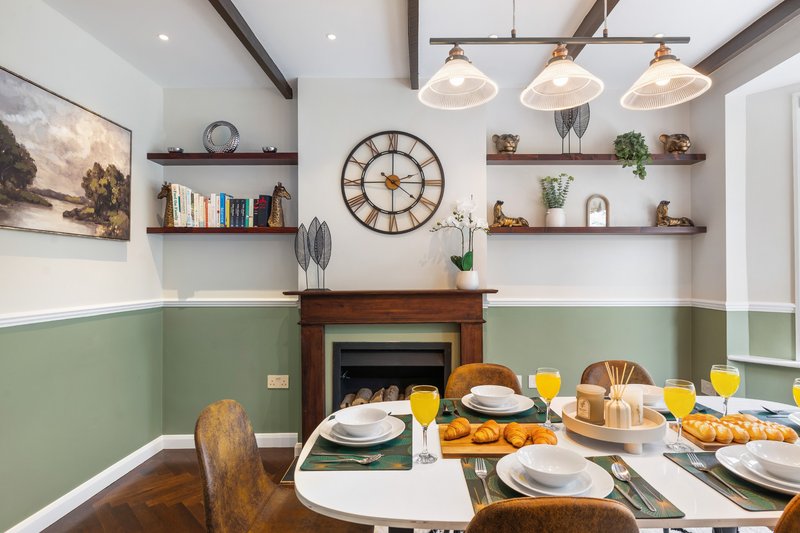 Dining room with fireplace, set table, pendant lights and open shelving