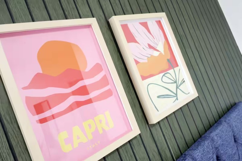 Two framed art prints with abstract designs on corrugated metal surface