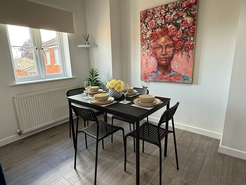 Dining room with black table, chairs, place settings, flowers and wall art