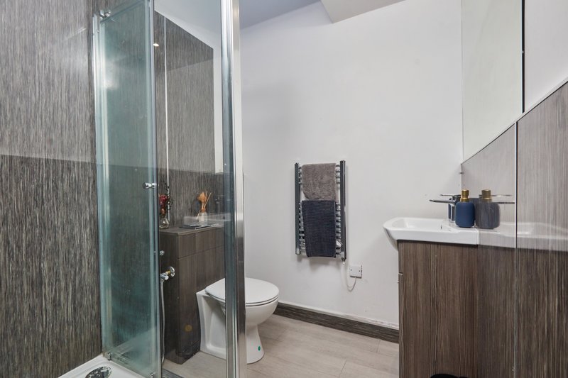 Modern bathroom with walk-in shower, toilet, vanity sink and towel rack