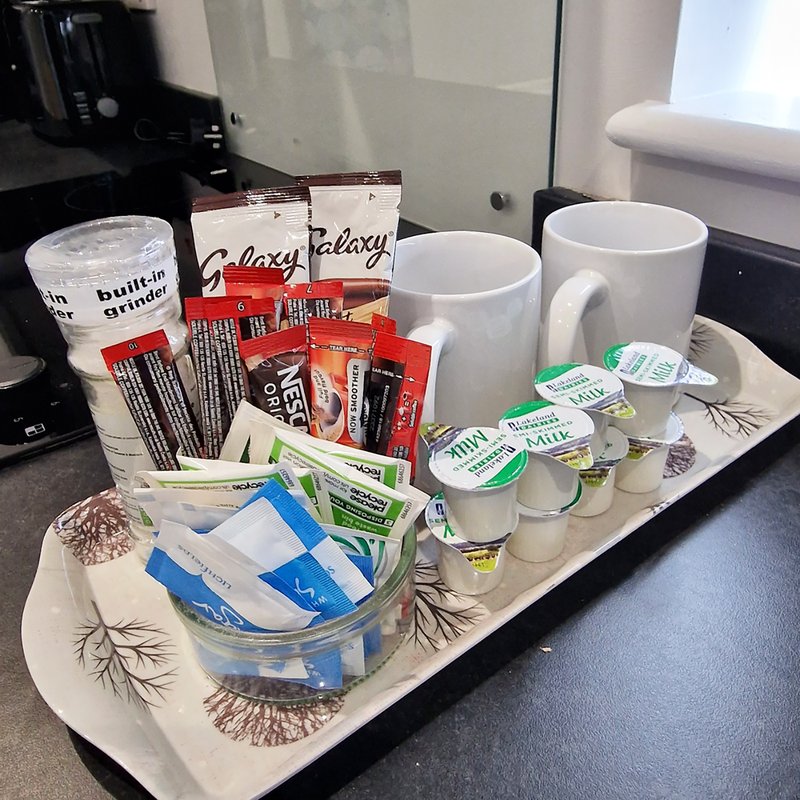 Kitchen counter display with mugs, tea boxes, coffee supplies and welcome amenities