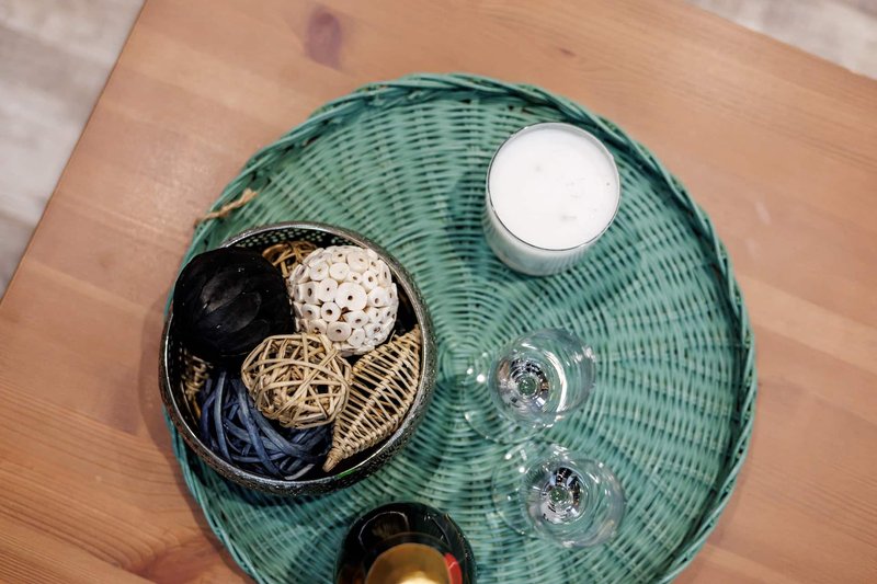 Overhead view of turquoise wicker table with decorative items and glassware