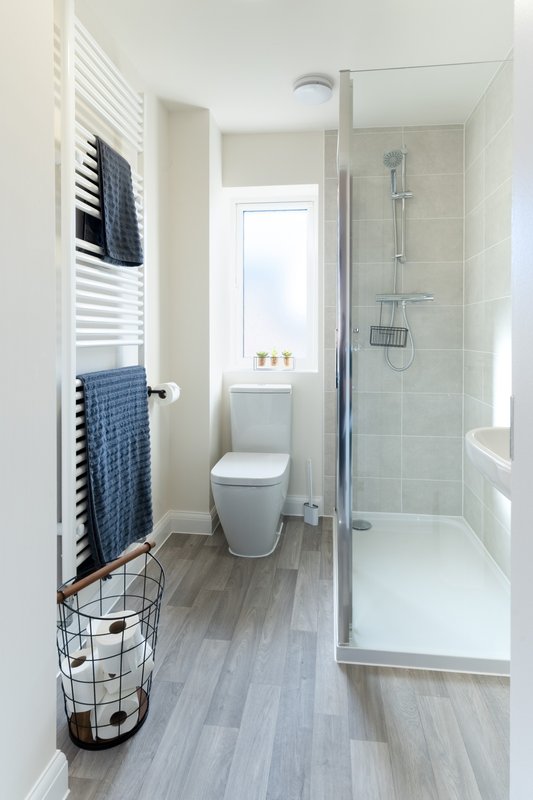 Modern bathroom with walk-in shower, toilet, heated towel rail and window