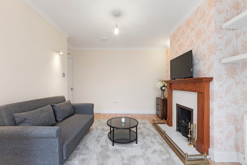 Living room with gray sofa, fireplace, TV mounted on wall, and round coffee table